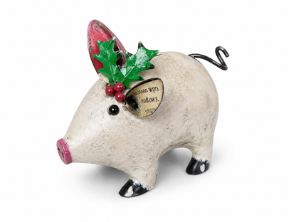 Decorative pig figurine with holly leaves and berries on a white background
