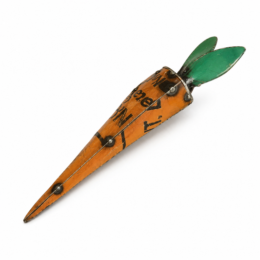 Metal carrot sculpture with green top on a white background