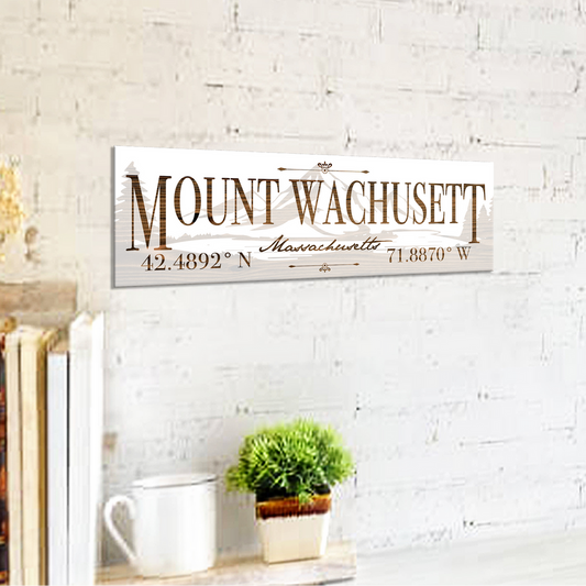 Decorative sign with 'Mount Wachusett, Massachusetts' text on a white brick wall background.