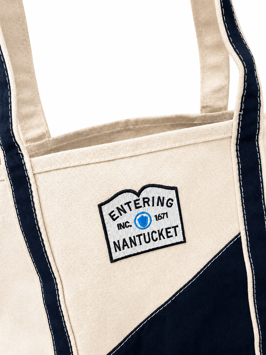 Beige tote bag with 'Entering Nantucket' logo on a white background