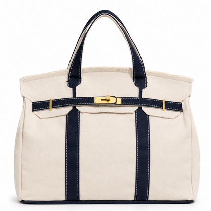 White tote bag with navy straps and a gold tag on a white background