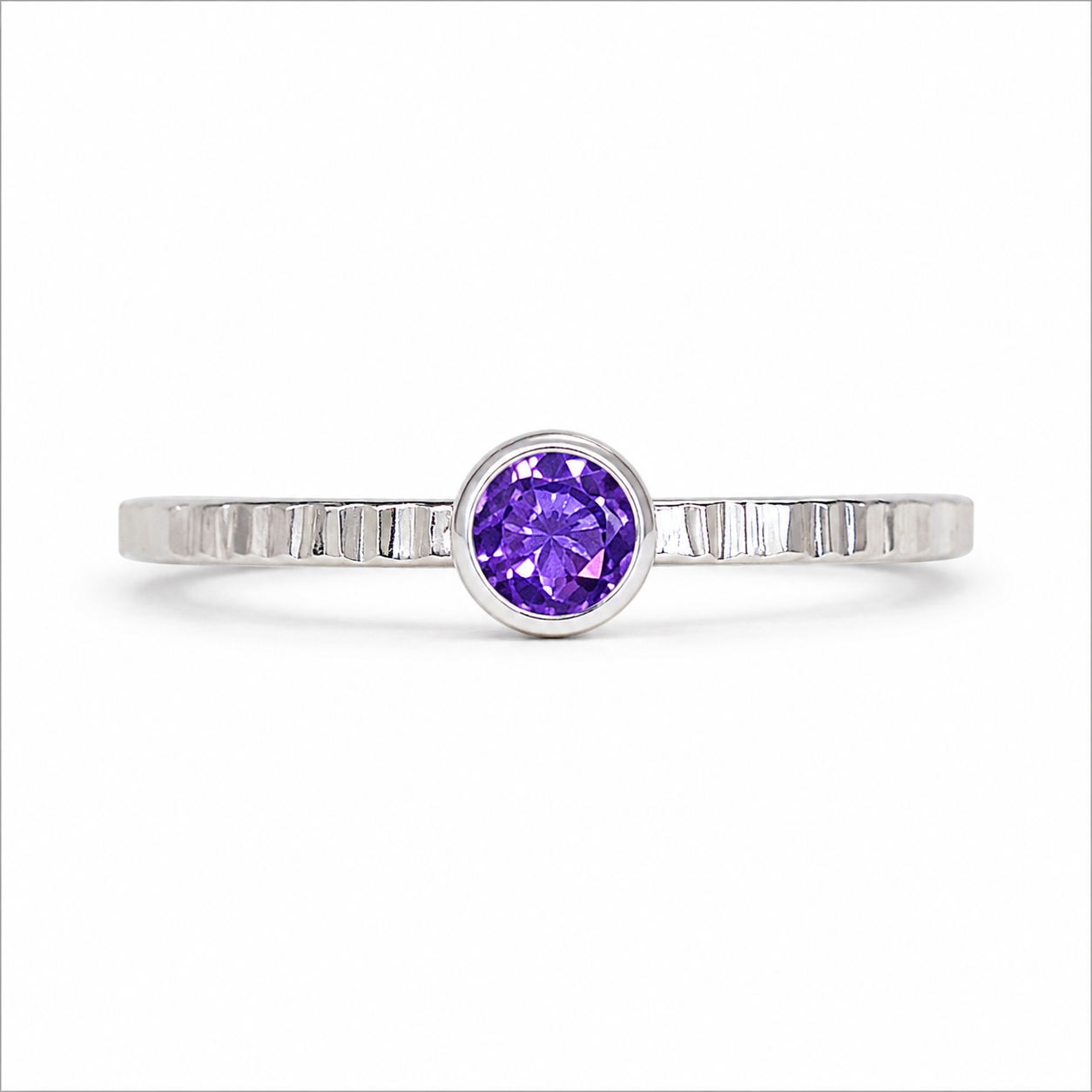 Silver ring with a purple gemstone on a white background