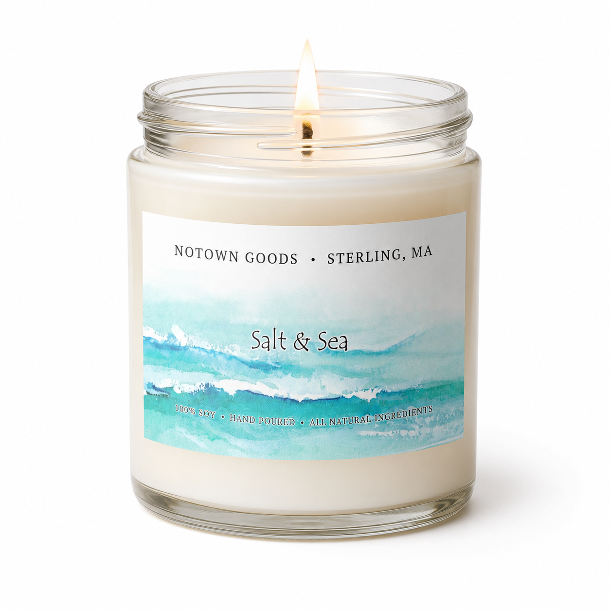 Clear jar candle with white wax and a decorative label on a white background.