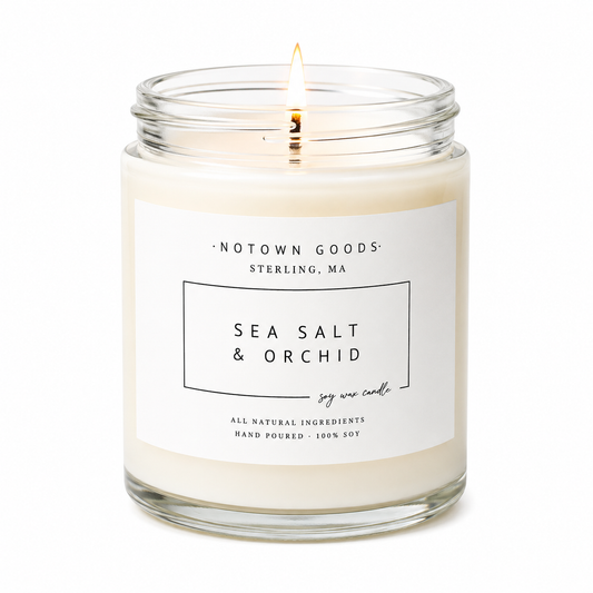 Clear jar candle with white wax and a decorative label on a white background.