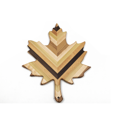 Wooden cutting board shaped like a maple leaf on a white background