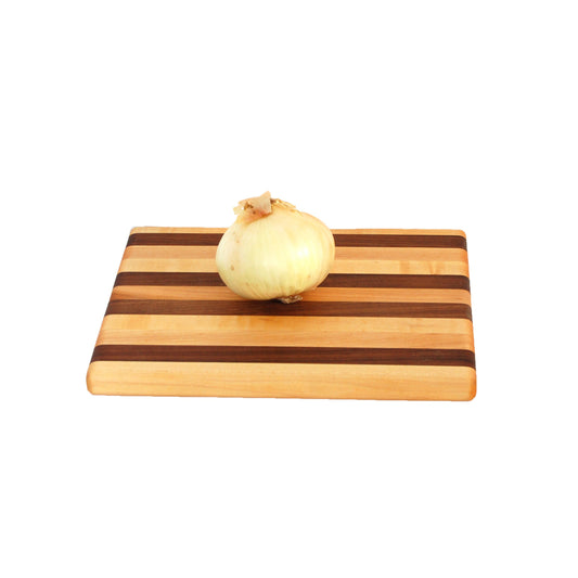 Wooden cutting board with a striped pattern on a white background with an onion on top.