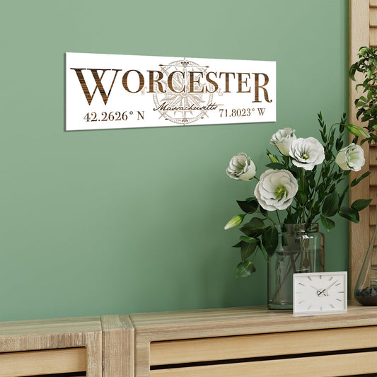 Decorative sign with 'Worcester' and coordinates on a green wall above a wooden sideboard with flowers and a clock.