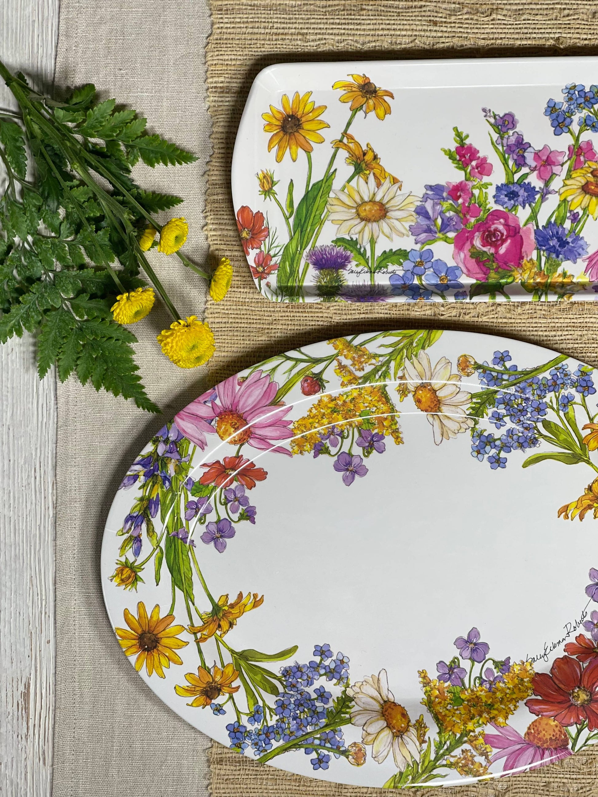Two platters with floral designs on a wooden surface.