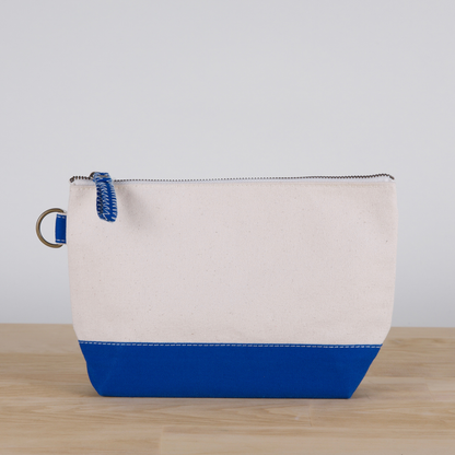 Canvas pouch with blue bottom section on a wooden surface