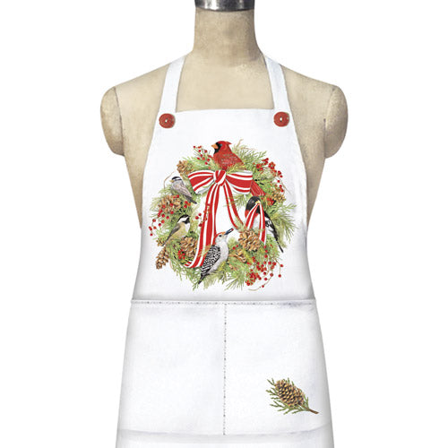 White apron with a decorative graphic of a red and white striped bow, birds, and winter foliage, featuring matching accent buttons and two large pockets.