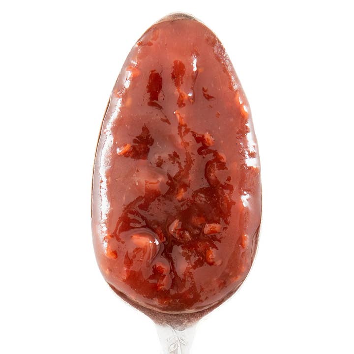 A spoonful of raspberry preserves on a white background.