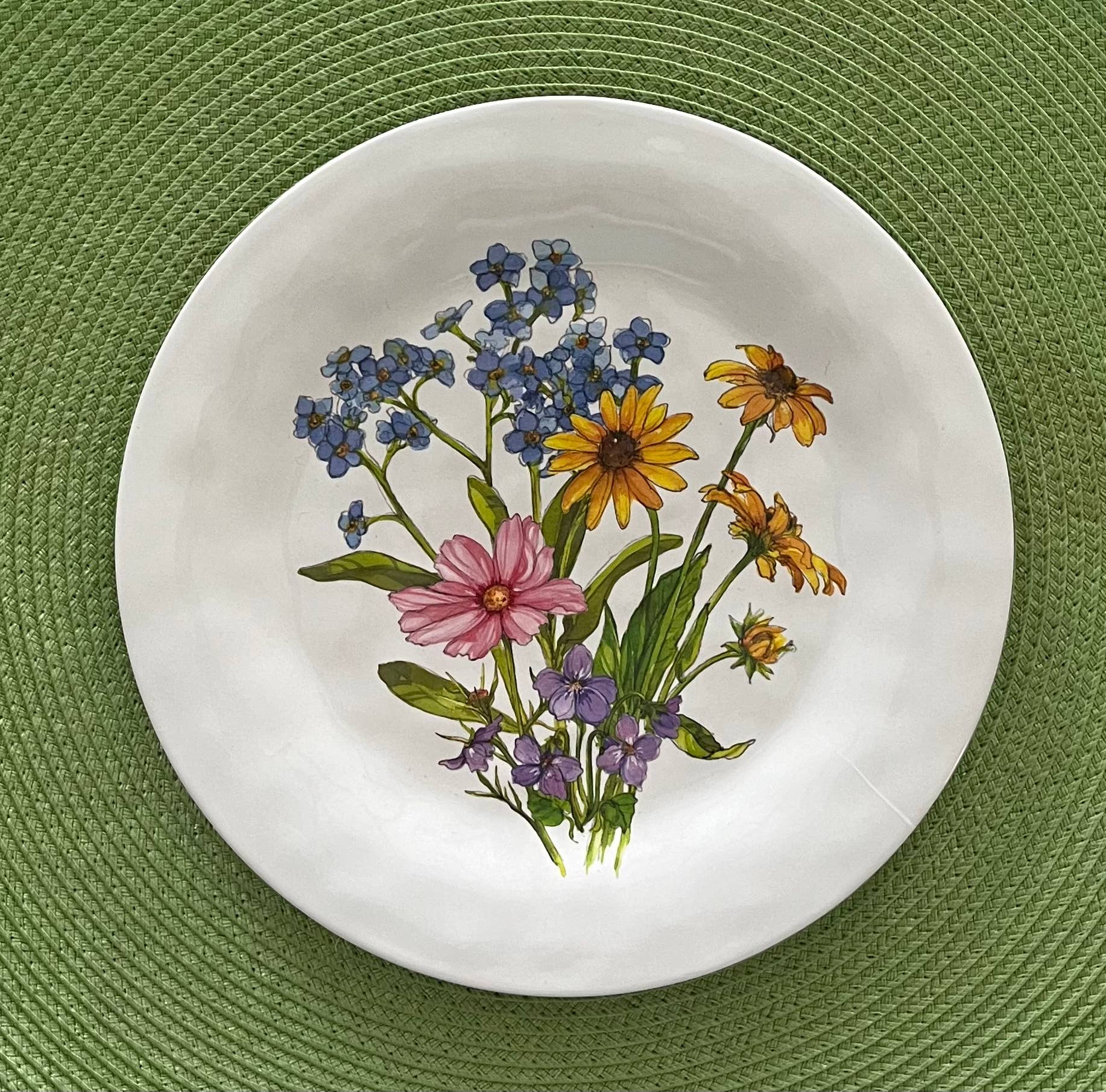 Decorative plate with floral design on a green textured surface