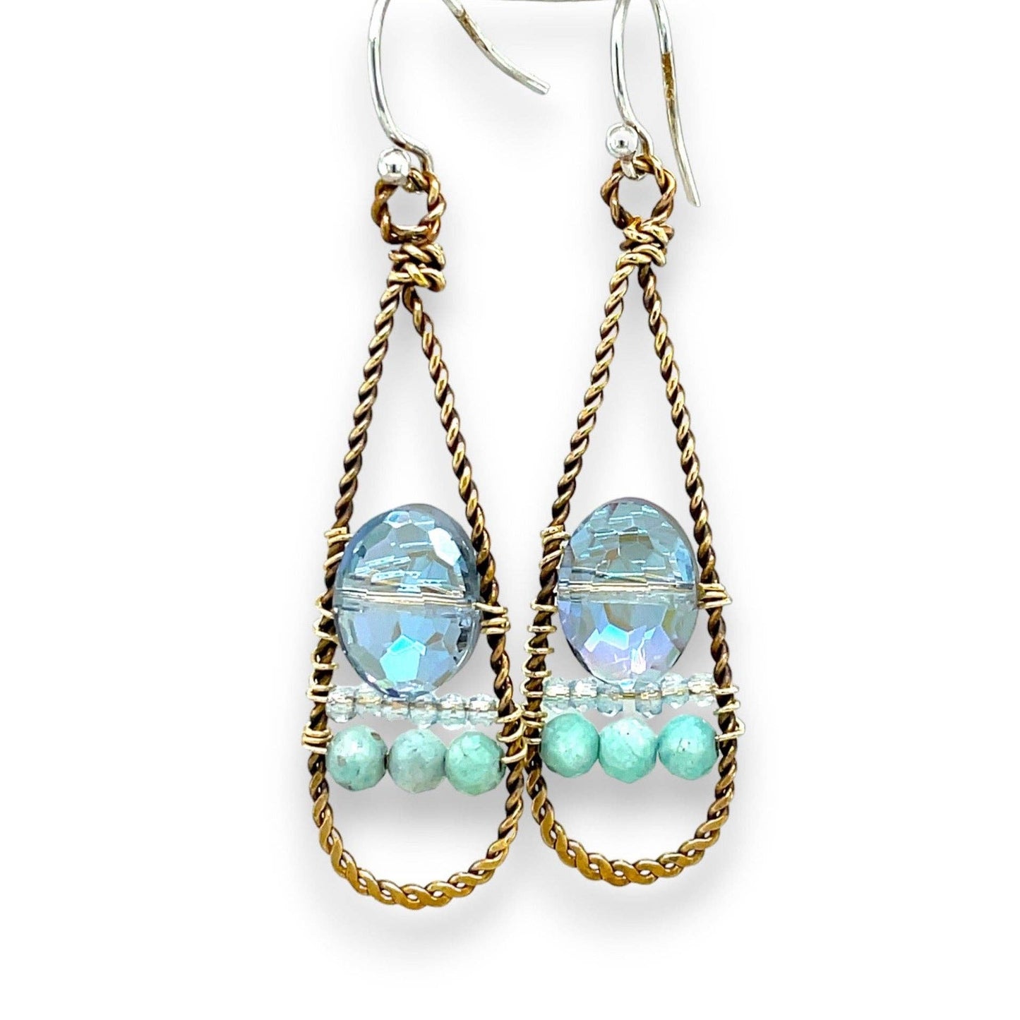 Pair of earrings with gold wire wrapping and blue and green beads on a white background