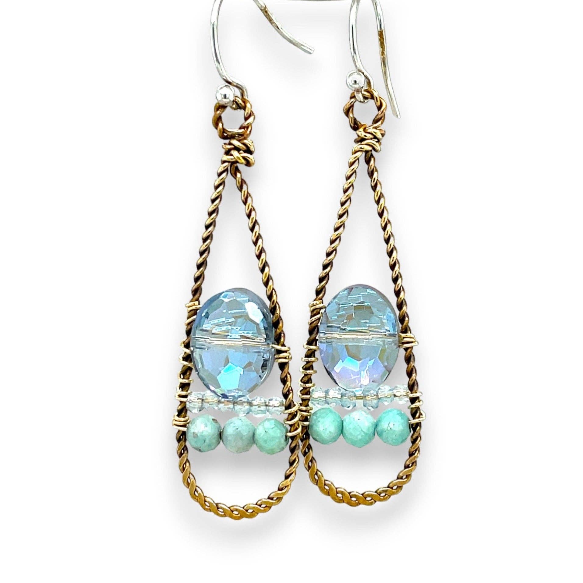 Pair of earrings with gold wire wrapping and blue and green beads on a white background