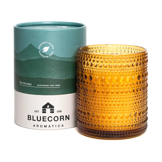 Amber textured candle with Bluecorn Aromatica packaging on a white background.