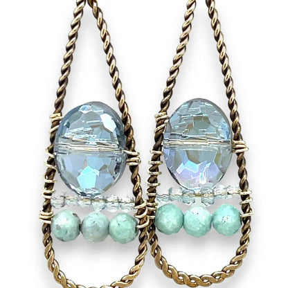 Pair of earrings with blue and green beads on a white background