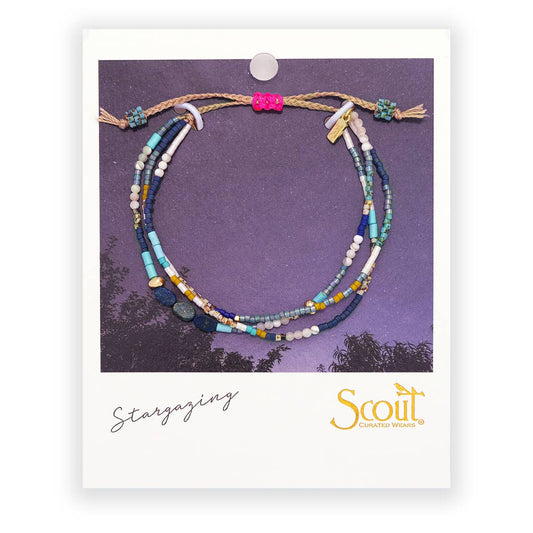 Colorful beaded bracelet on a Scout branded card with a purple background