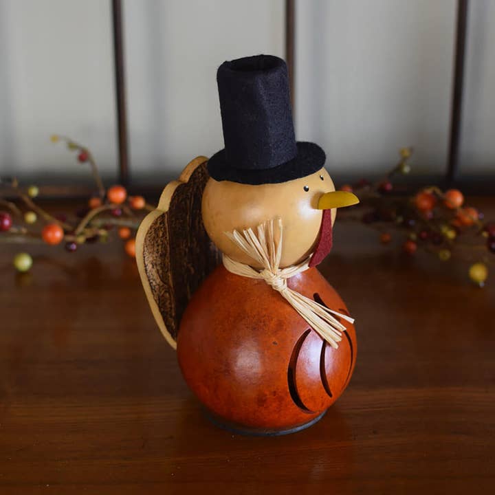 Decorative turkey with a top hat on a wooden surface with blurred background