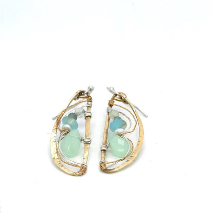 Pair of earrings with gold wire wrapping and green gemstones on a white background