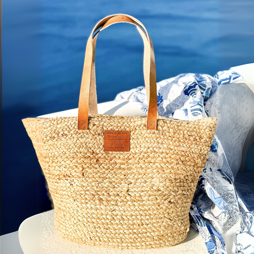 Woven straw bag with leather straps on a boat against a blue water background