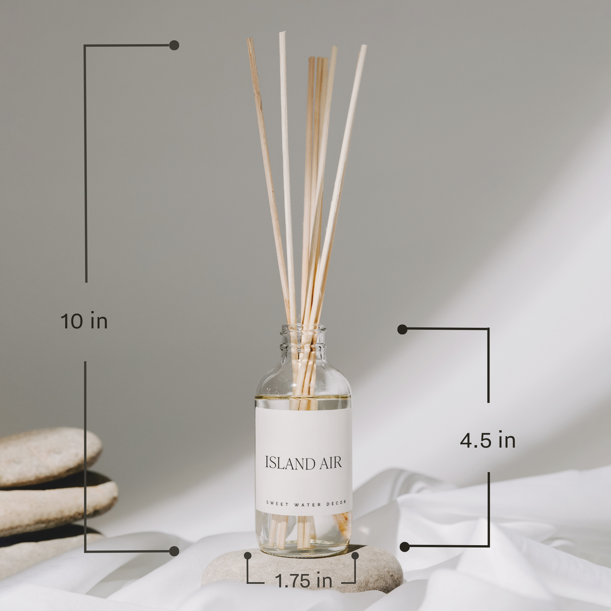 Diffuser bottle labeled 'Island Air' with measurements on a neutral background