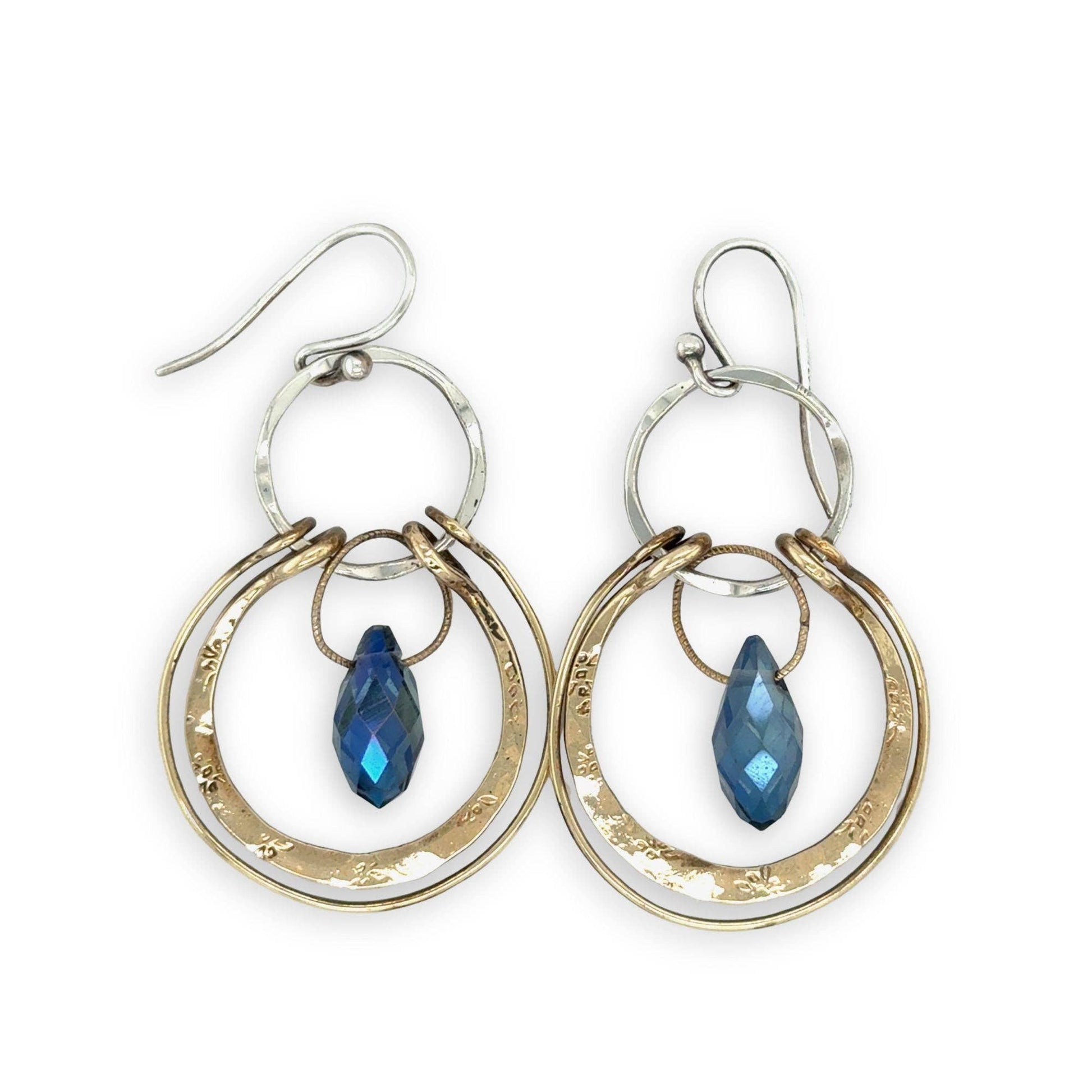 Pair of hoop earrings with blue gemstones on a white background