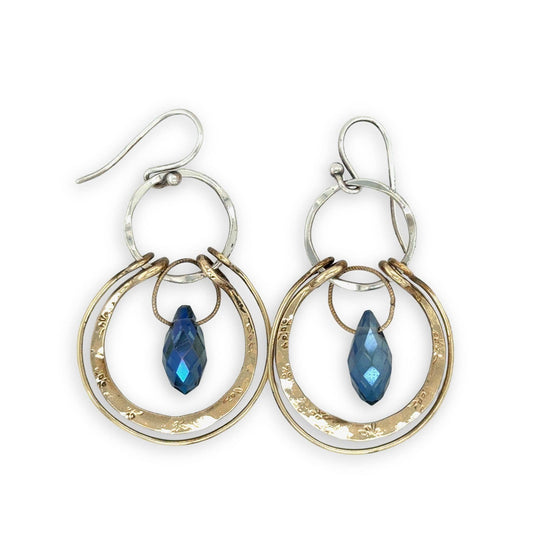 Pair of hoop earrings with blue gemstones on a white background