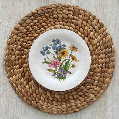 White plate with floral design on a woven placemat