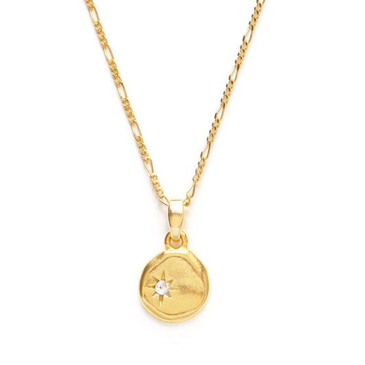 Gold necklace with a round pendant on a white background