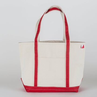 White tote bag with red handles and trim on a light gray background