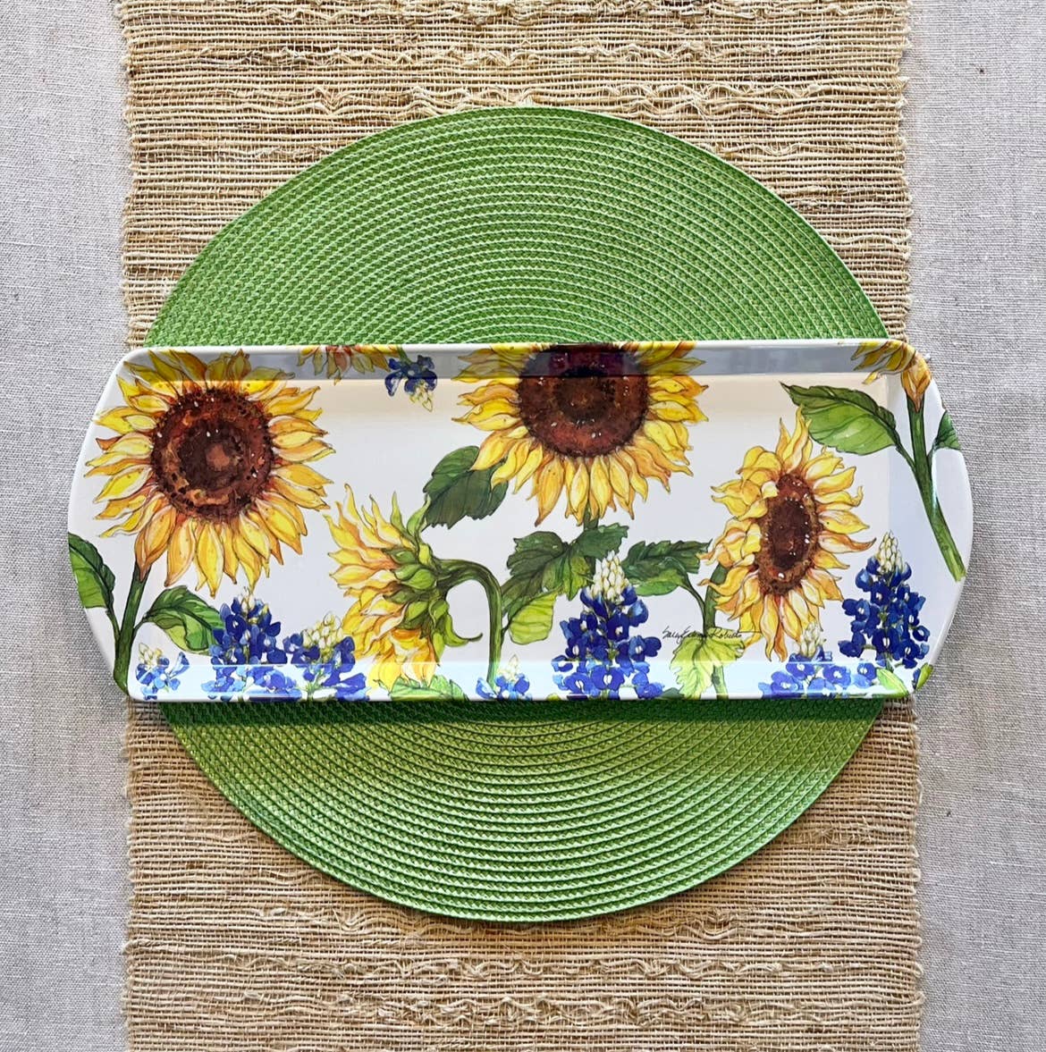 Decorative tray with sunflower design on a green plate and placemat.