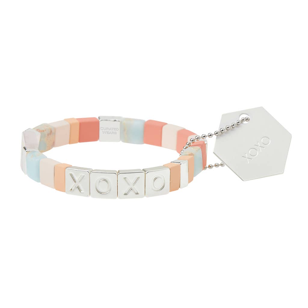 Bracelet with colorful hexagonal beads and 'XOXO' charm on a white background