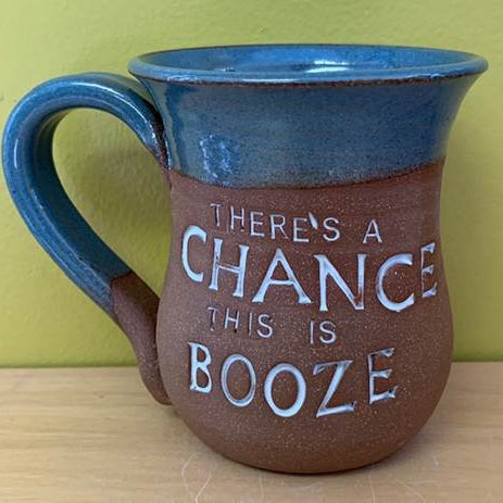 Blue and brown ceramic mug with text 'THERE'S A CHANCE THIS IS BOOZE' on a wooden surface.