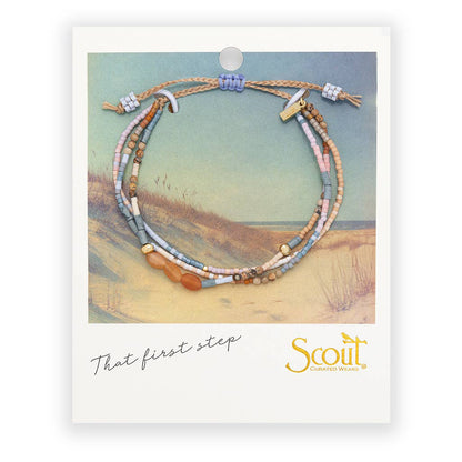 Beaded bracelets on a card with a scenic background and 'Scout' branding.