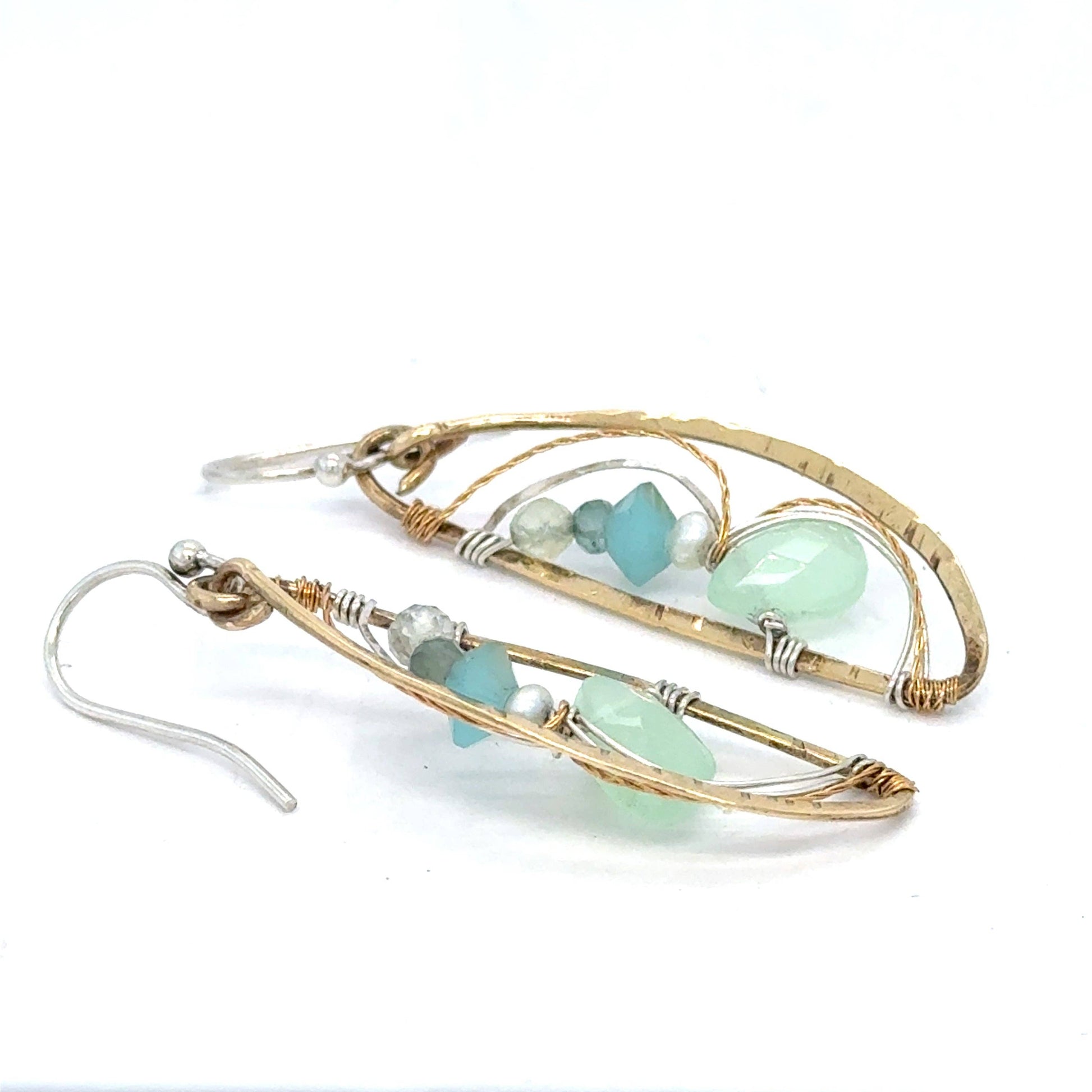 Gold and silver earrings with green beads on a white background