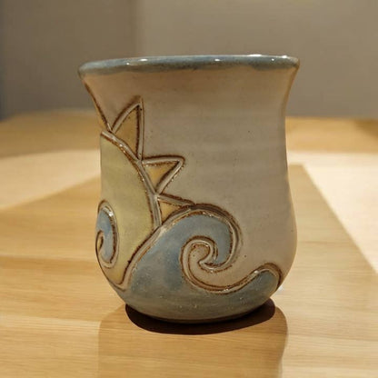 Ceramic cup with decorative design on a wooden surface