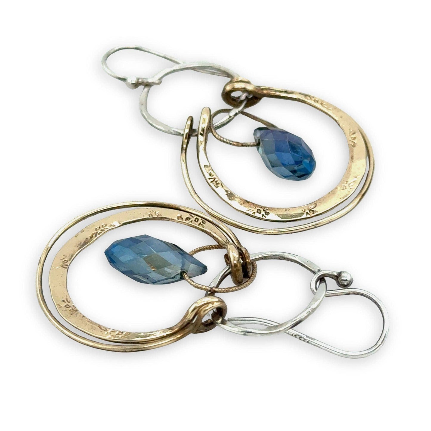 Pair of hoop earrings with blue gemstones on a white background