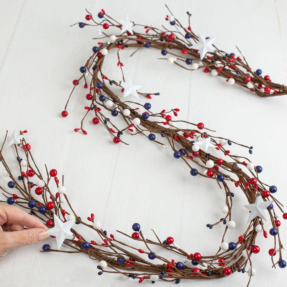 Decorative garland with red, blue, and white berries on a white background