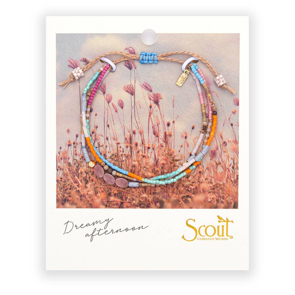 Set of colorful beaded bracelets on a Scout branded card with a nature-themed background