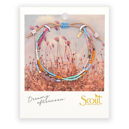 Set of colorful beaded bracelets on a Scout branded card with a nature-themed background