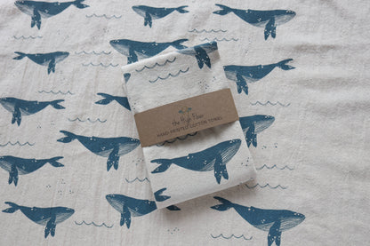 Folded towel with whale pattern on a fabric background