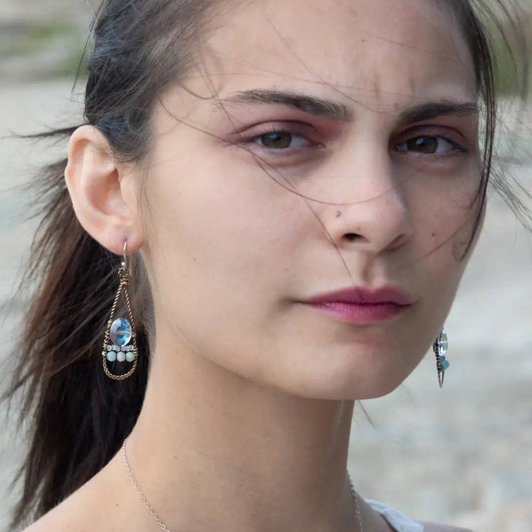 Close-up of a woman wearing earrings with a blurred natural background