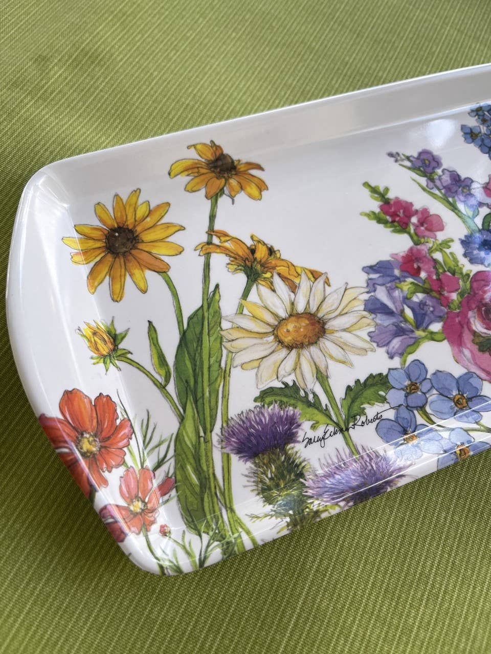 Decorative tray with floral design on a green surface