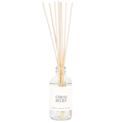 Diffuser bottle labeled 'Stress Relief' with wooden sticks on a white background