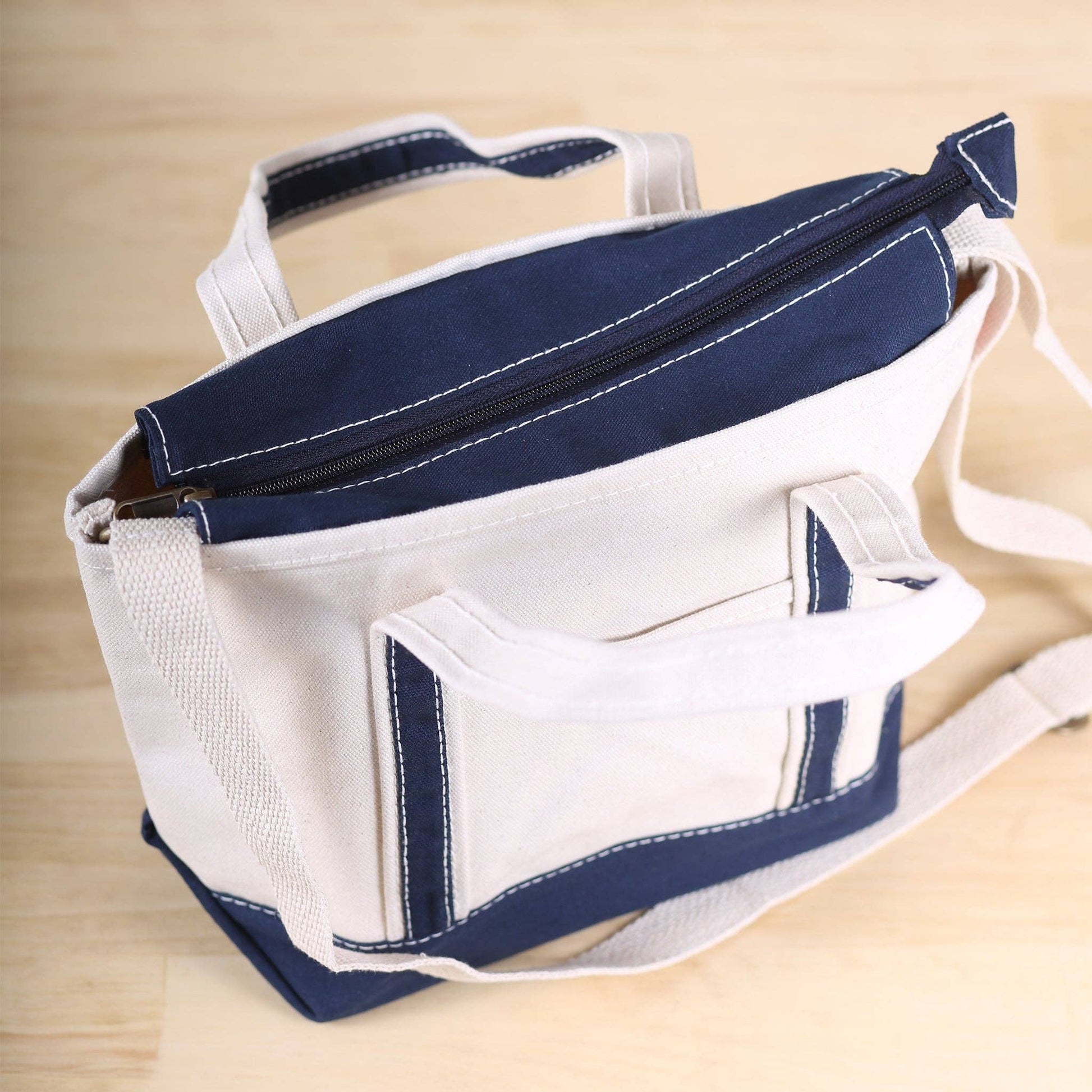 White and navy bag with a handle on a wooden surface