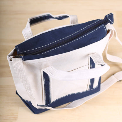 White and navy bag with a handle on a wooden surface