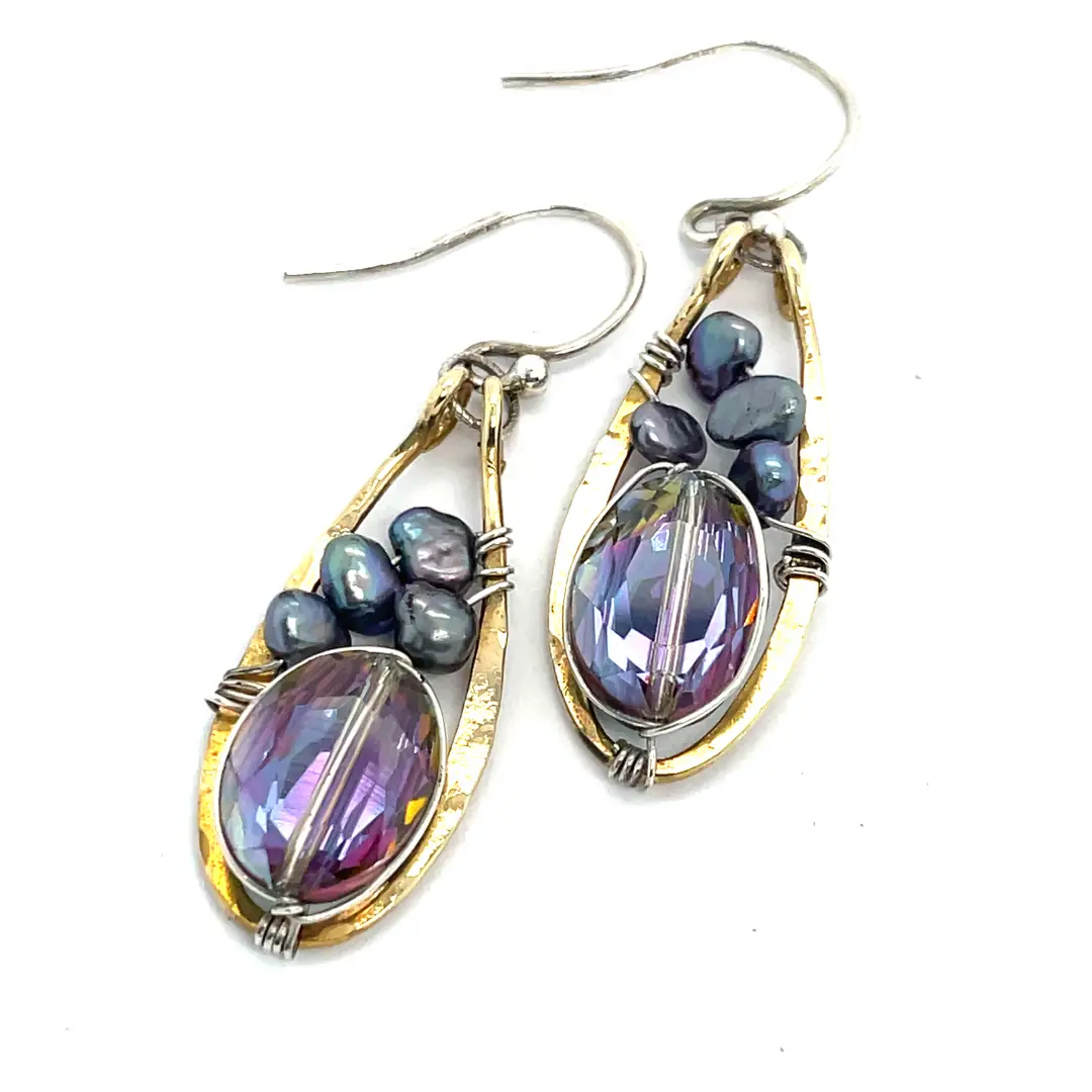 Pair of earrings with purple gemstones and gold accents on a white background