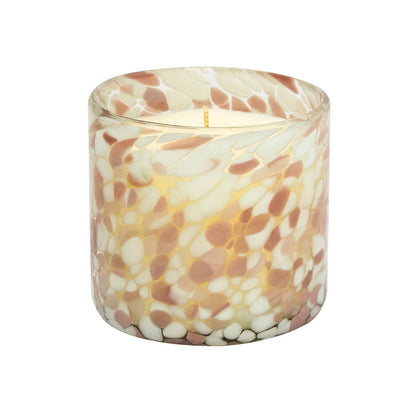 Candle in a decorative glass container with a marbled pattern on a white background