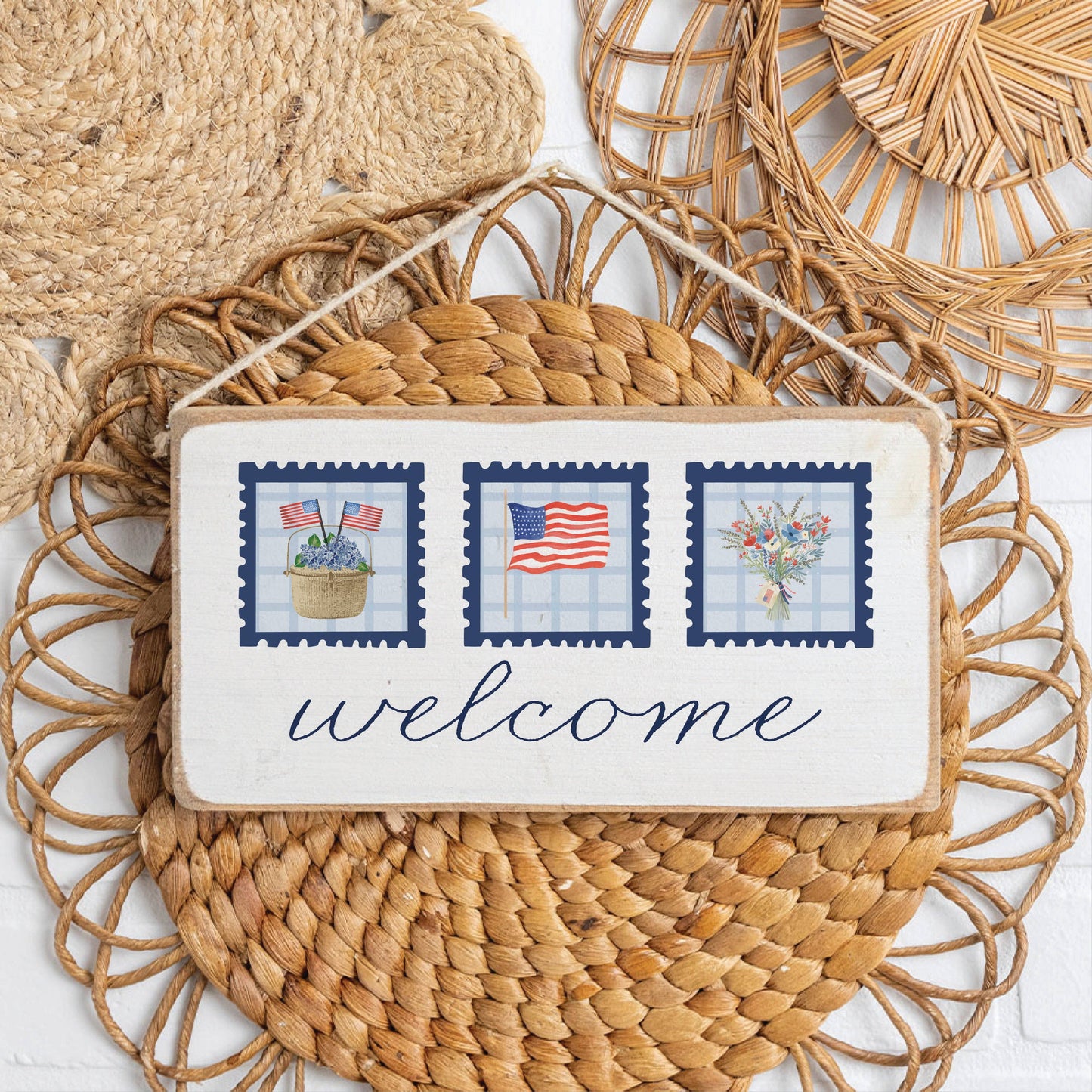 Decorative sign with 'welcome' text and patriotic design on a woven mat.