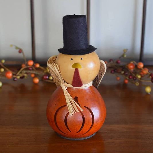 Decorative turkey with a top hat on a wooden surface with blurred background